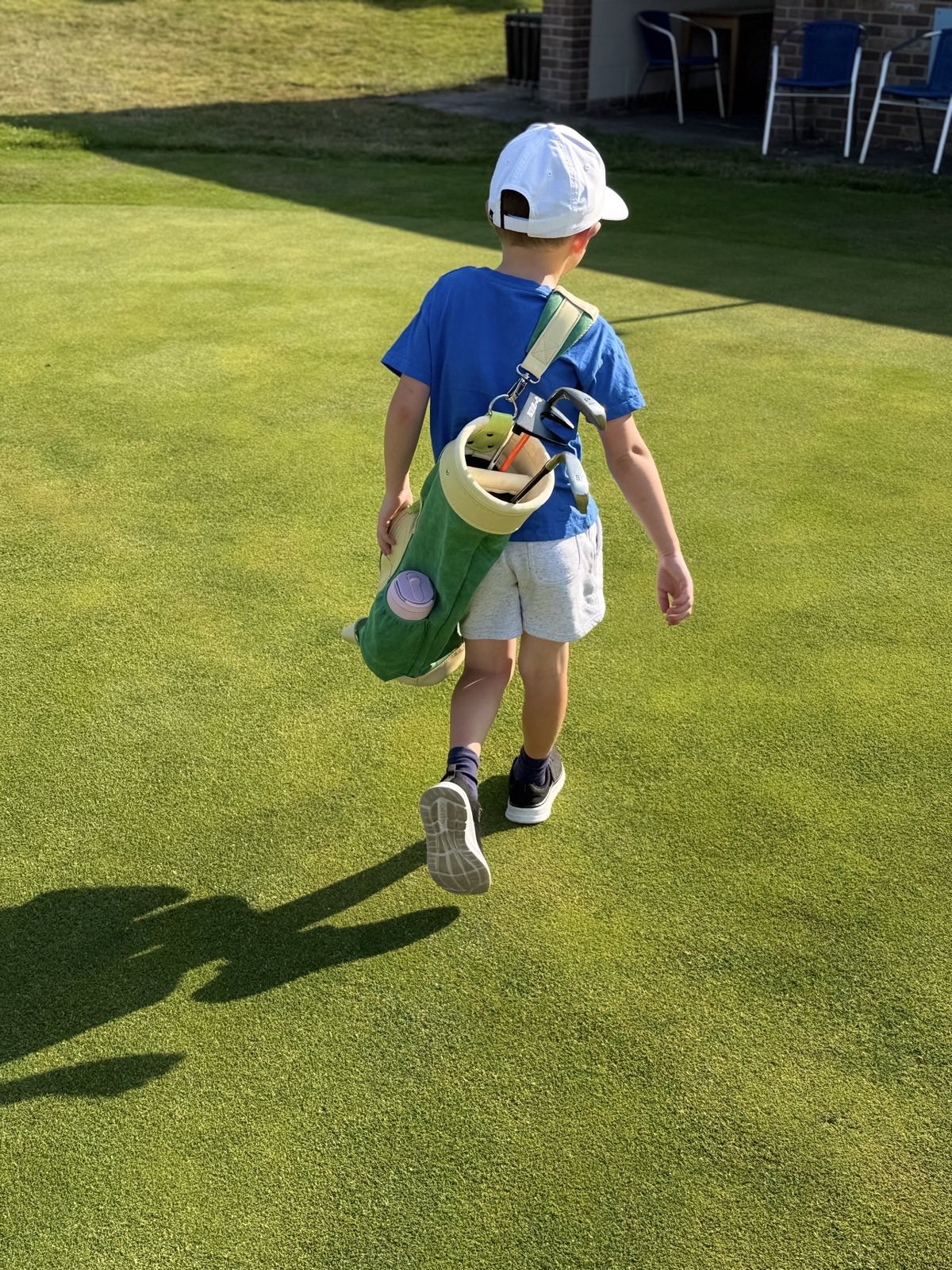 Junior golfer carrying his Moose Golf bag on the course